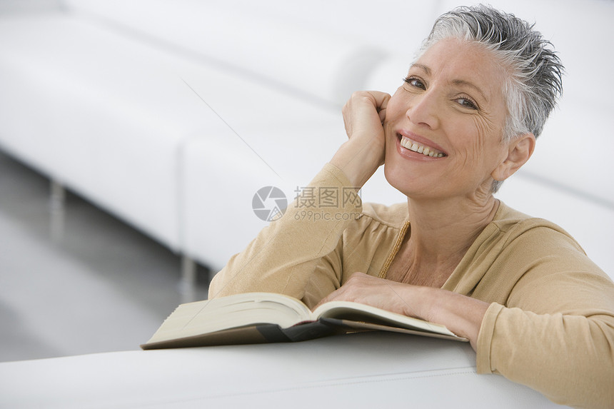 在家沙发上写书的笑笑老女人的肖像公寓阅读成人文学退休水平享受婴儿短发娱乐图片
