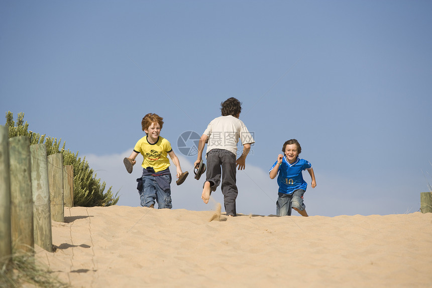 3个小男孩跑向海滩休闲服装幸福精神童年微笑赤脚活力假期跑步图片