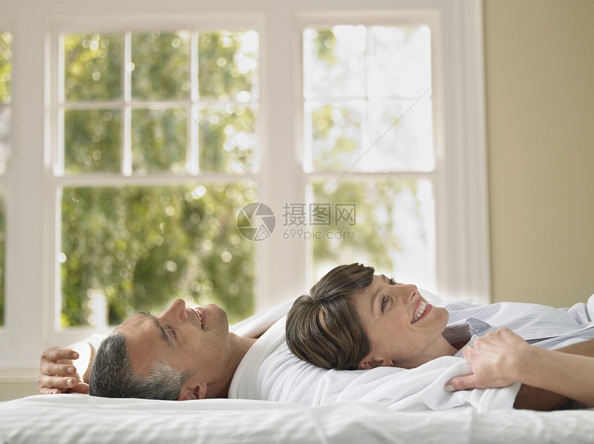 幸福女人的侧面观 在床上看着时躺在丈夫身边图片