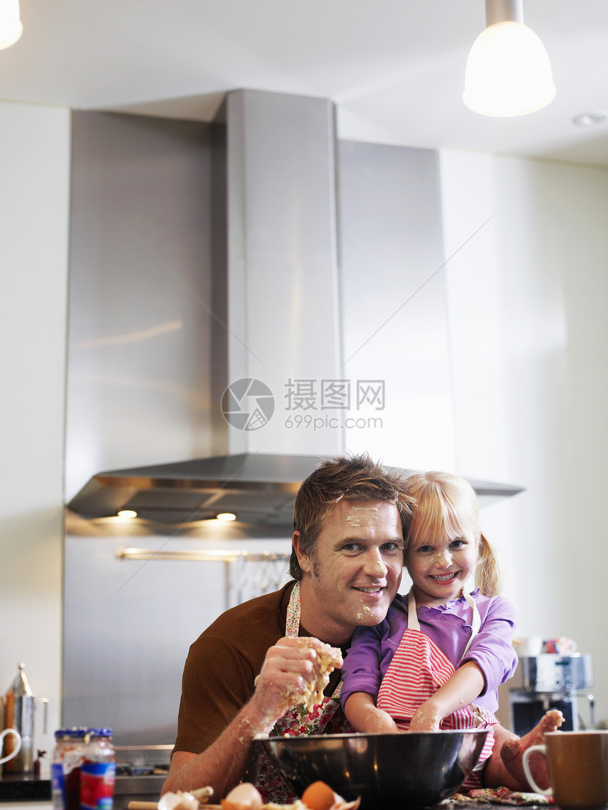 快乐的父亲和女儿在厨房烘烤的肖像图片