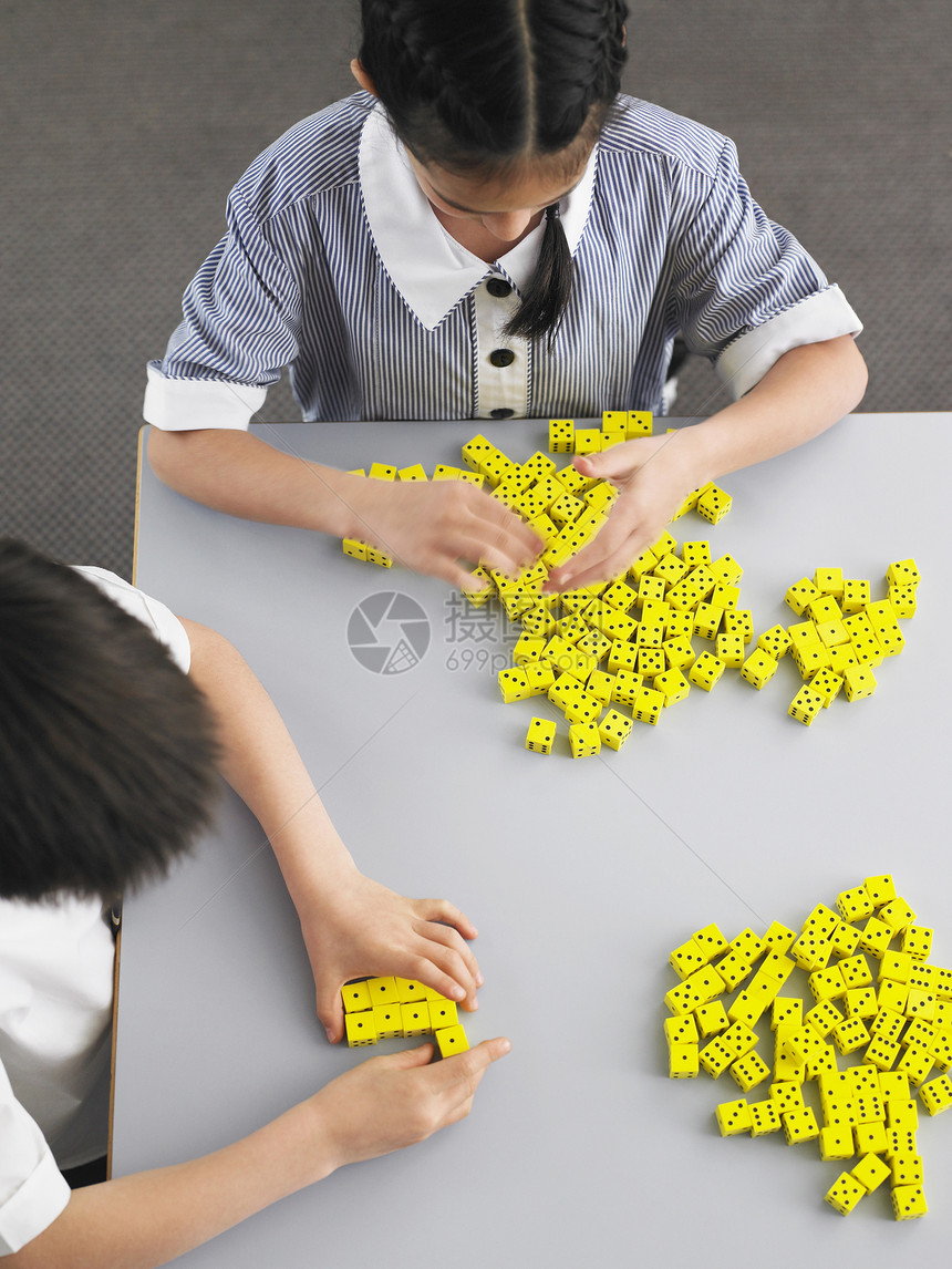 小学学生在课堂上用骰子在书桌上玩图片