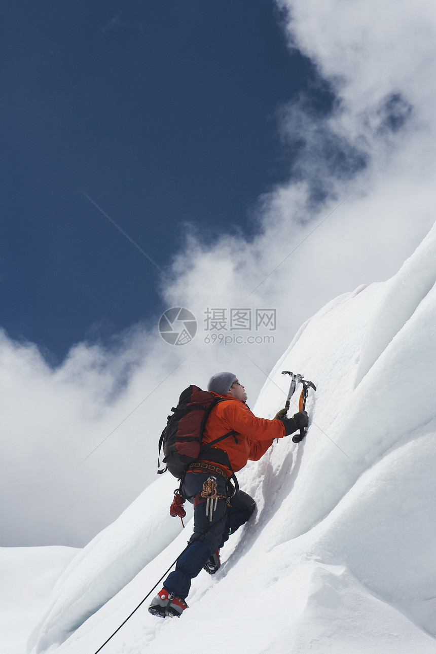 一名男性登山者的低角度视图 他们向雪坡上爬去 用斧子挡云运动地形安全山腰闲暇成人天空娱乐活动滑雪图片