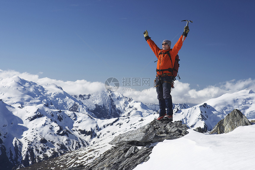 男性登山者举起手来 在雪峰顶上用冰夹享受冒险家背包假期登山成人地形男人天空顶峰图片