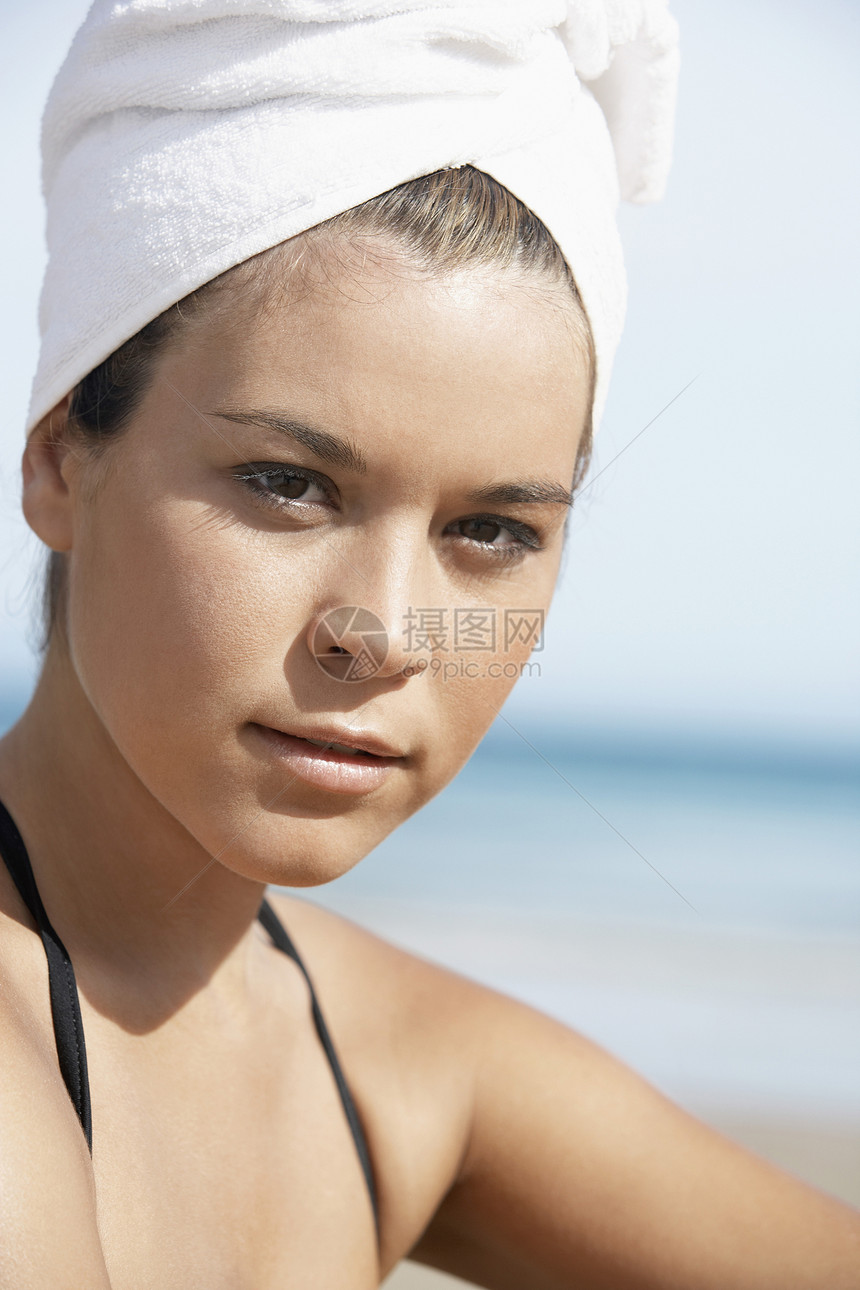 美丽的年轻美女的肖像 在海滩上用毛巾包着头发图片