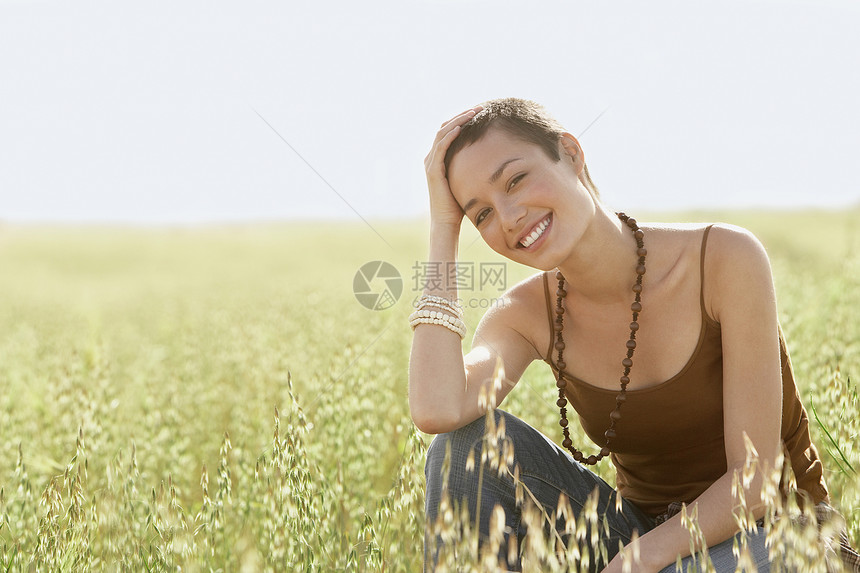 年轻妇女在草地上屈卧的肖像背心远足者旅行远足女性自由场地短发成人娱乐图片