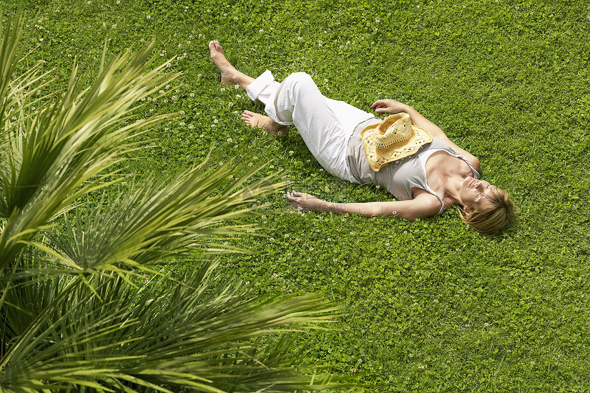 中年妇女在草地上睡觉的高角度视角图片