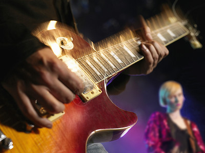 女摇滚吉他手在舞台上 与吉他中部特写合奏背景图片