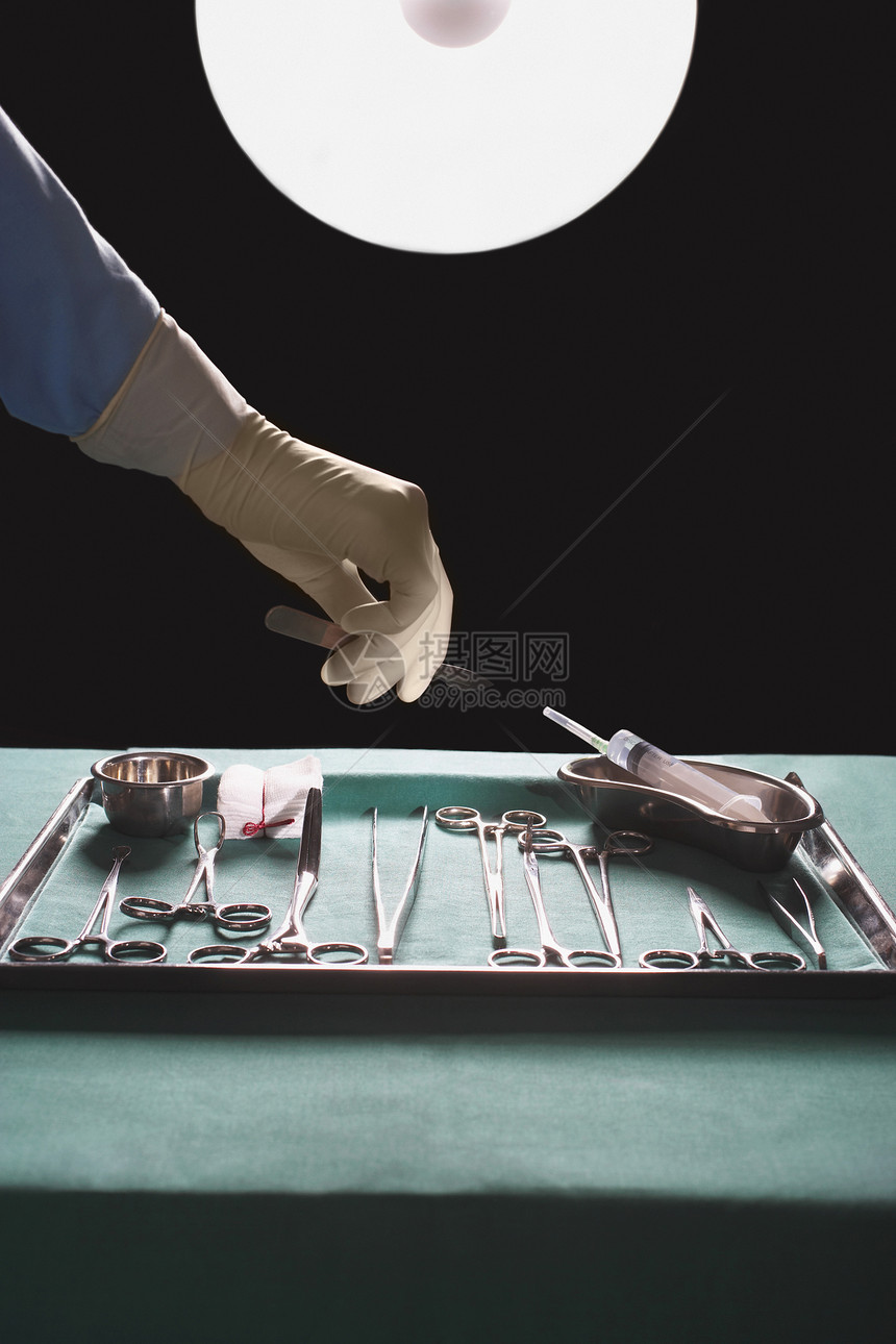 外科医生在手术室手伸手获取医疗设备时的关紧图片