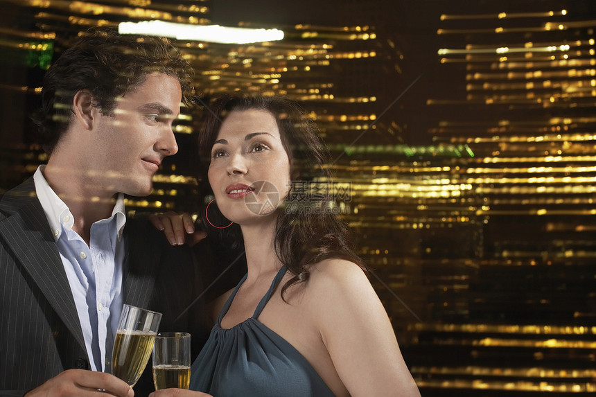一对年轻夫妇在夜空中 与香槟交锋的一对小情侣图片