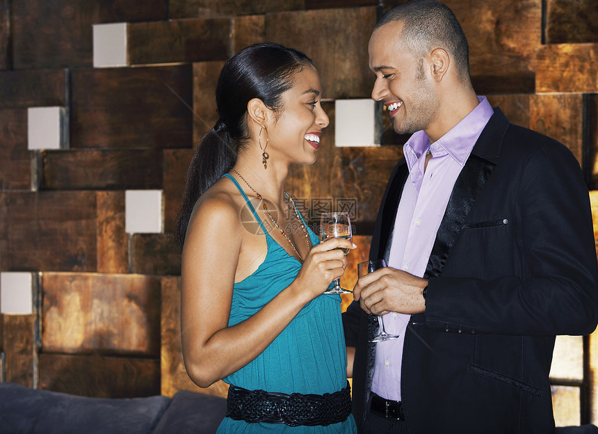 一边看一对微笑的情侣在酒吧里与喝酒面对面图片