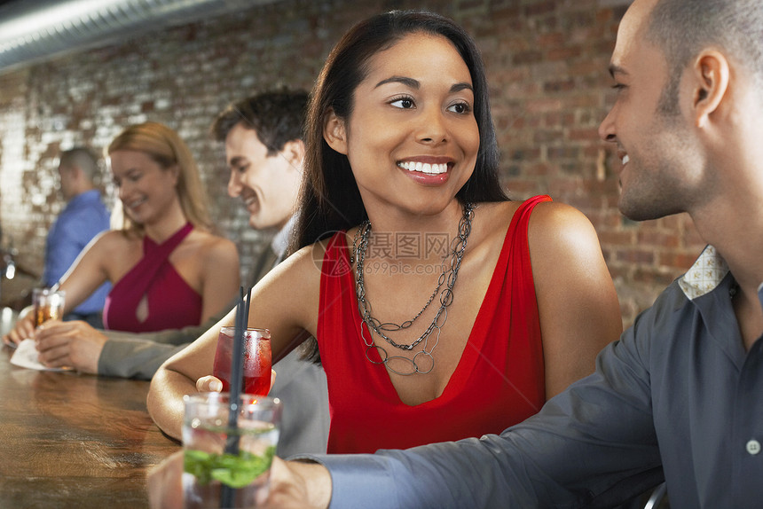 多民族快乐的一对夫妇 鸡尾酒坐在酒吧图片