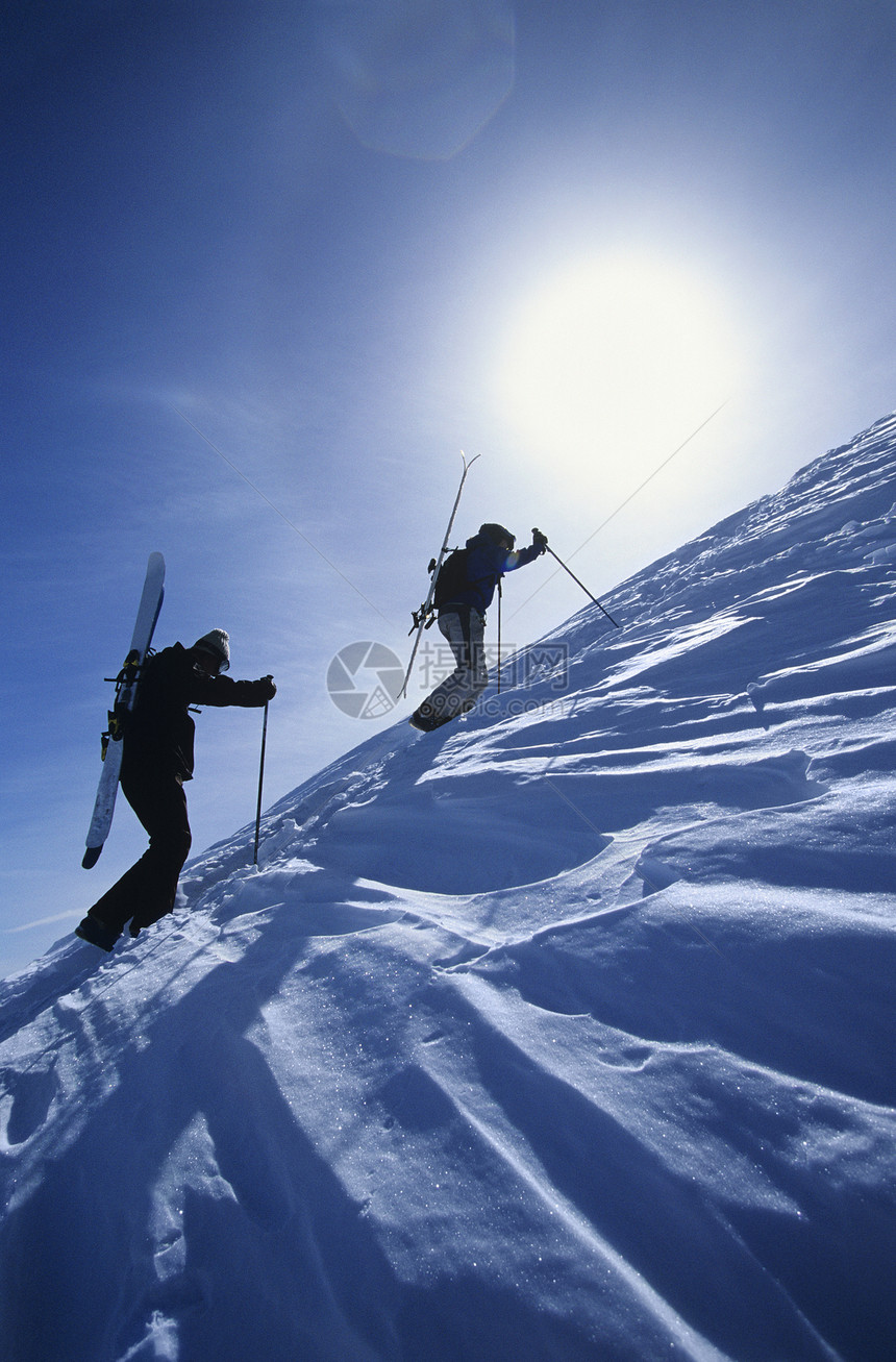 前往山顶登山的滑雪徒阳光低角度两个人极限滑雪板愿望成人视图男人顶峰图片