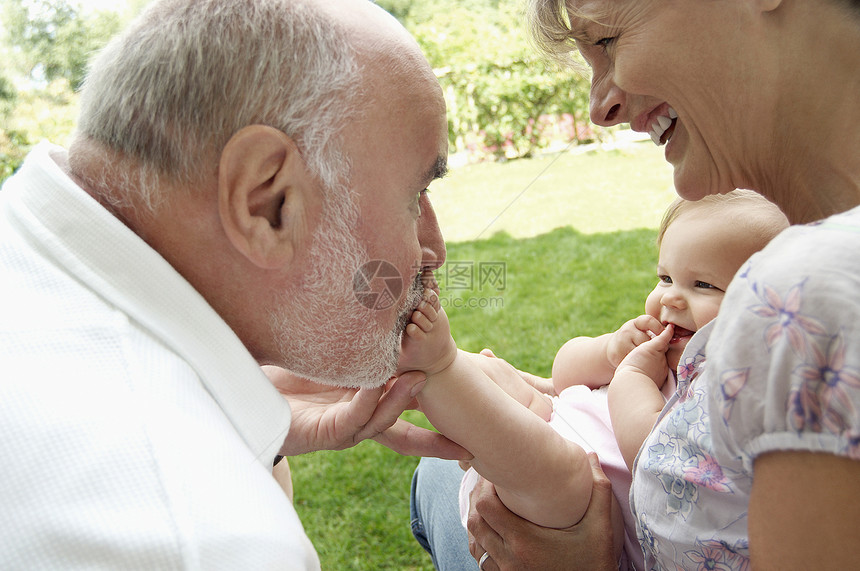 快乐的祖父母在花园里和孙女玩耍图片