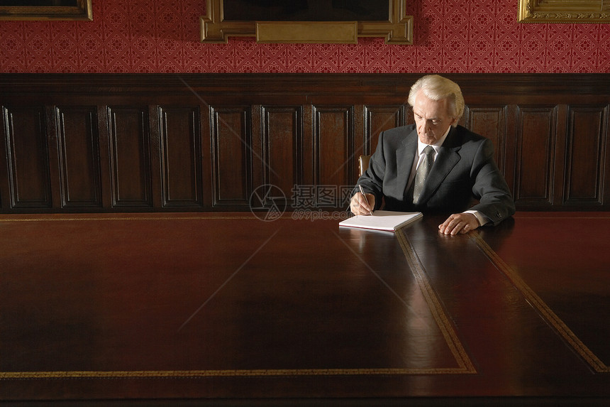 高级商务人士在会议桌上书上写作桌子男人房间人士商业领导权威会议室男士律师图片