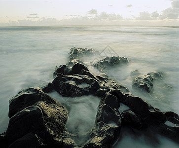 海岸岩石间喷雾背景图片