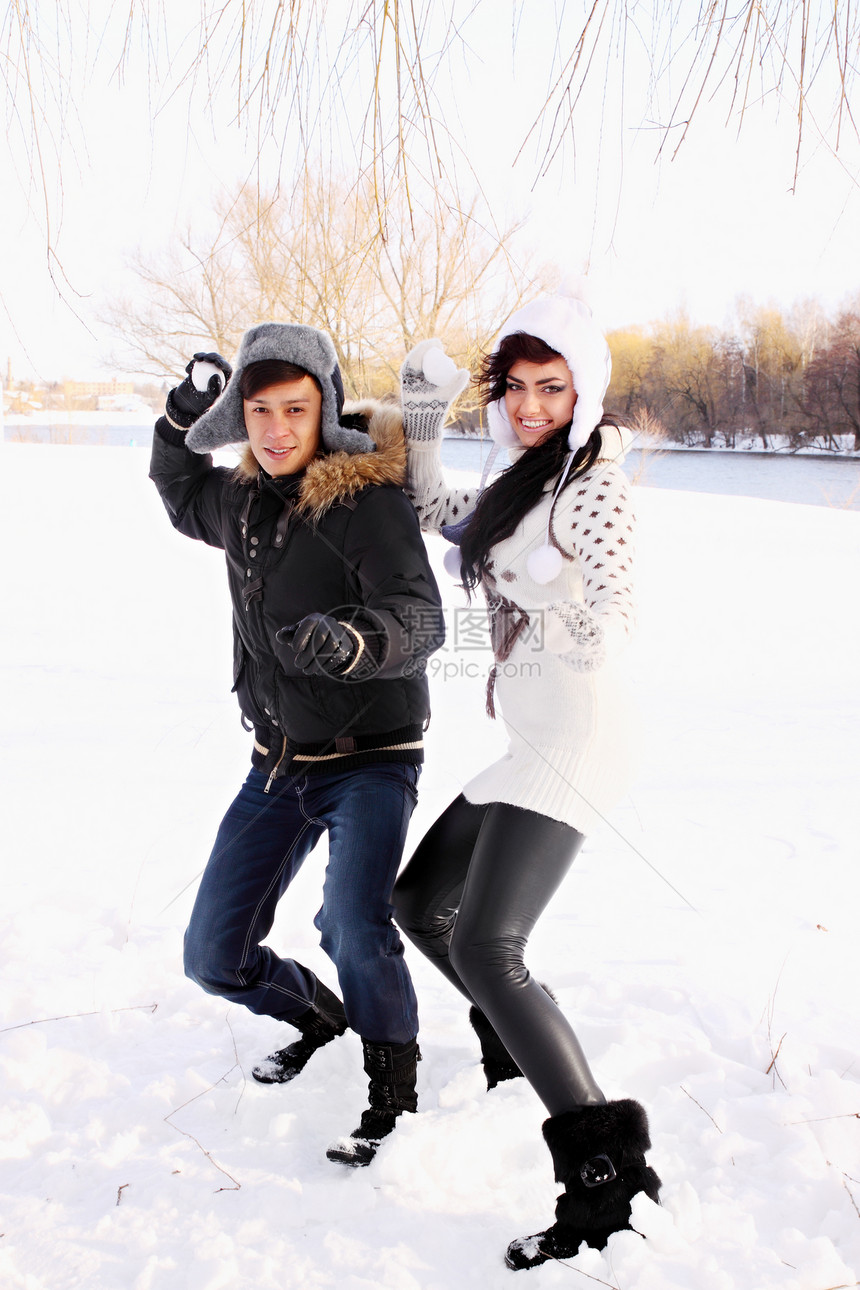 一对夫妇扔雪球帽子男人下雪娱乐季节衣服男性成年人喜悦夫妻图片