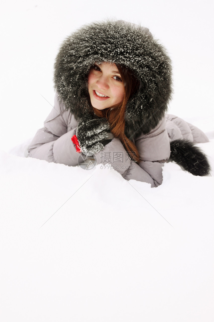 女孩躺在雪中文化说谎女性雪花外套季节幸福兜帽喜悦快乐图片