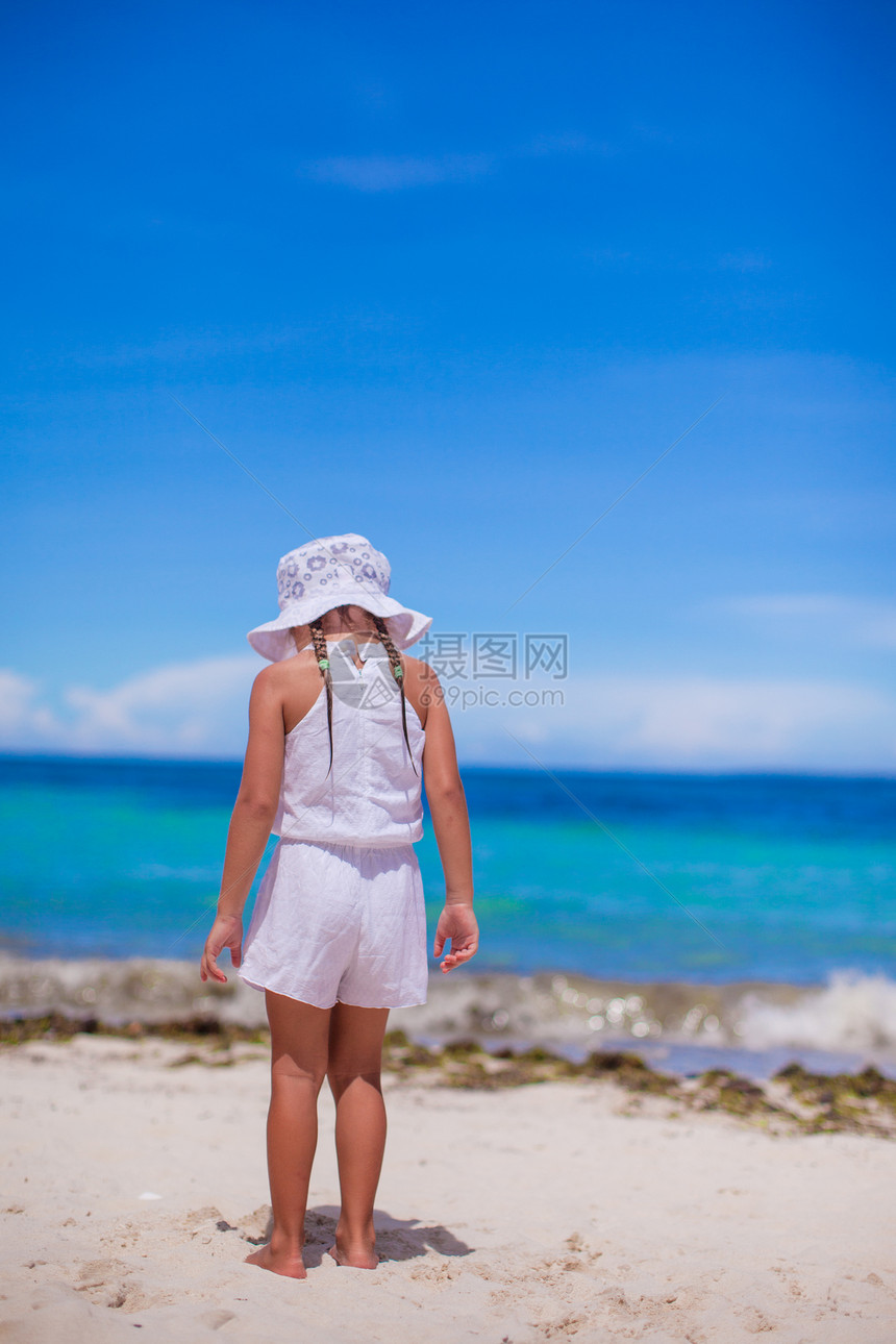 可爱的小女孩独自看着白沙滩上的海面图片