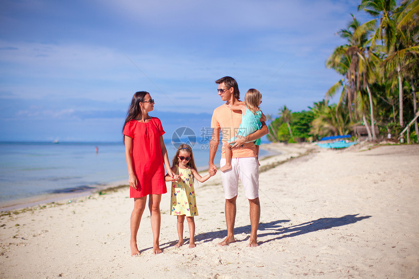 有两个孩子的年轻家庭在暑假沙滩度假图片