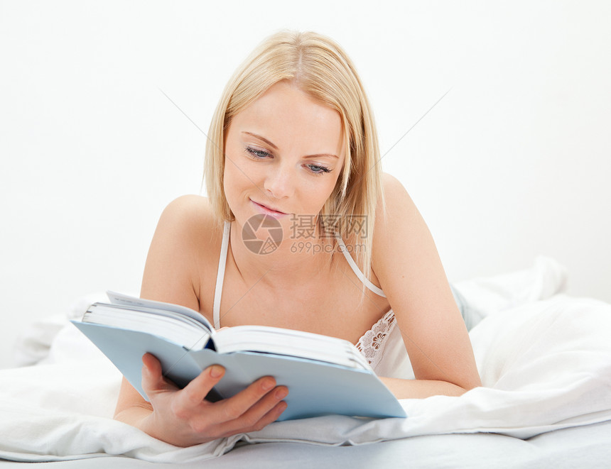 年轻美貌女性阅读书房间微笑女士枕头黑发喜悦说谎女孩卧室幸福图片