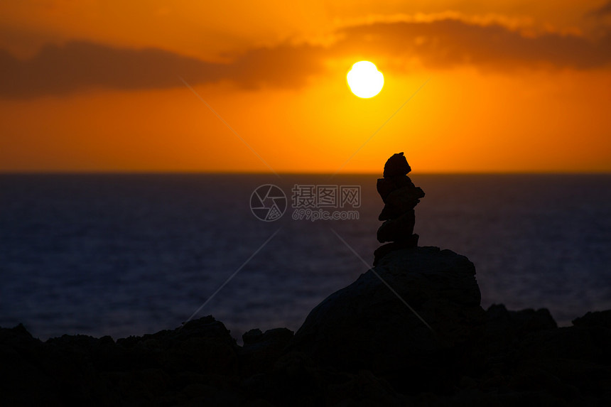 地中海日落时许愿的堆积石石头反射编队海洋旅行海岸太阳天空支撑海景图片