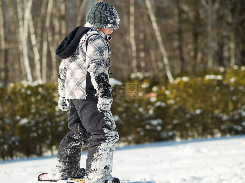男孩在雪中玩耍童年孩子季节男生生活乐趣青年滑雪板白色男性图片