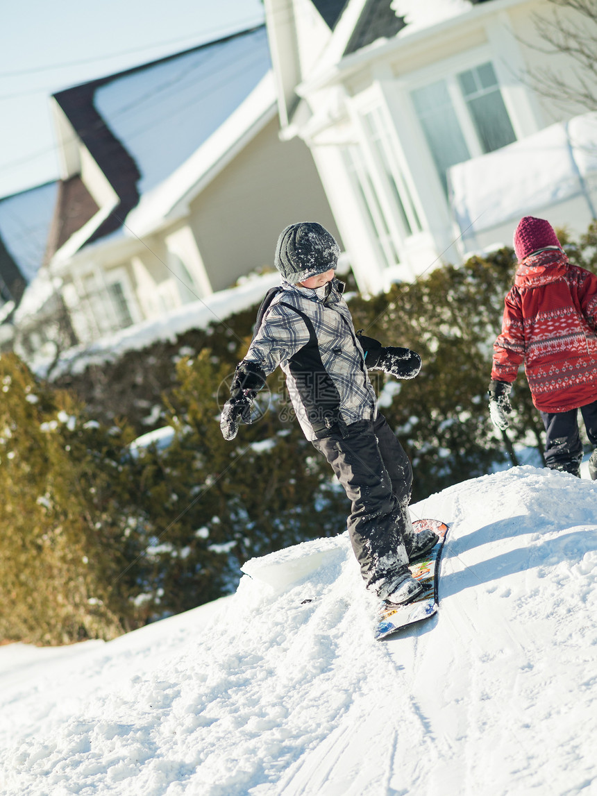 男孩在雪中玩耍滑雪板生活童年季节男生白色青年乐趣男性孩子图片