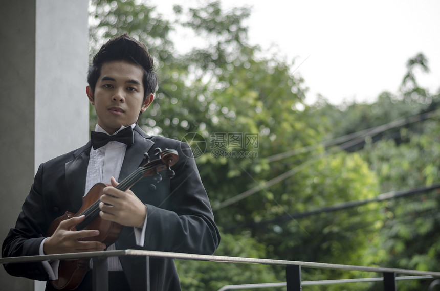 带着小提琴的艾西亚人音乐乐器音乐会男性玩家娱乐艺术家交响乐乐队音乐家图片