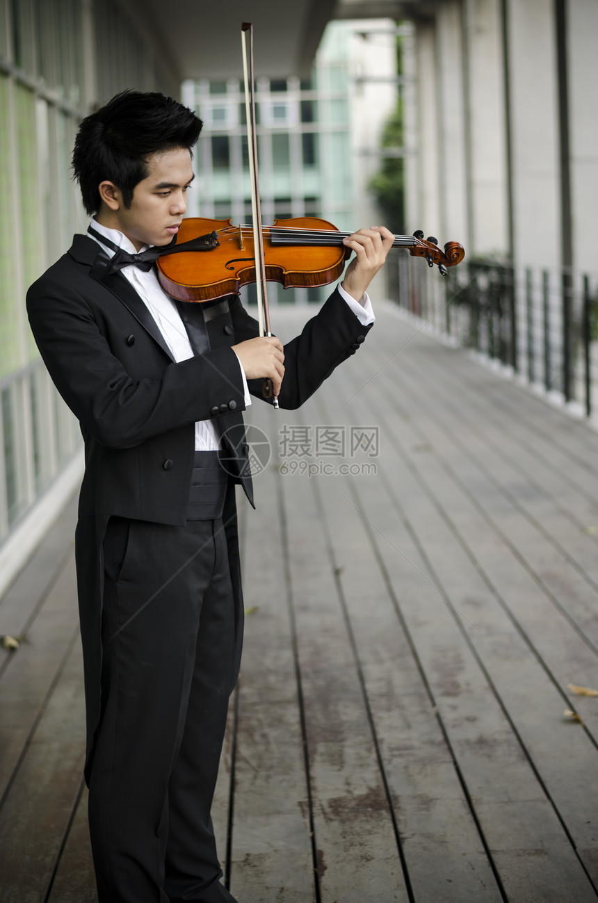 带着小提琴的艾西亚人乐队交响乐木头娱乐音乐家男性享受音乐会细绳演奏家图片