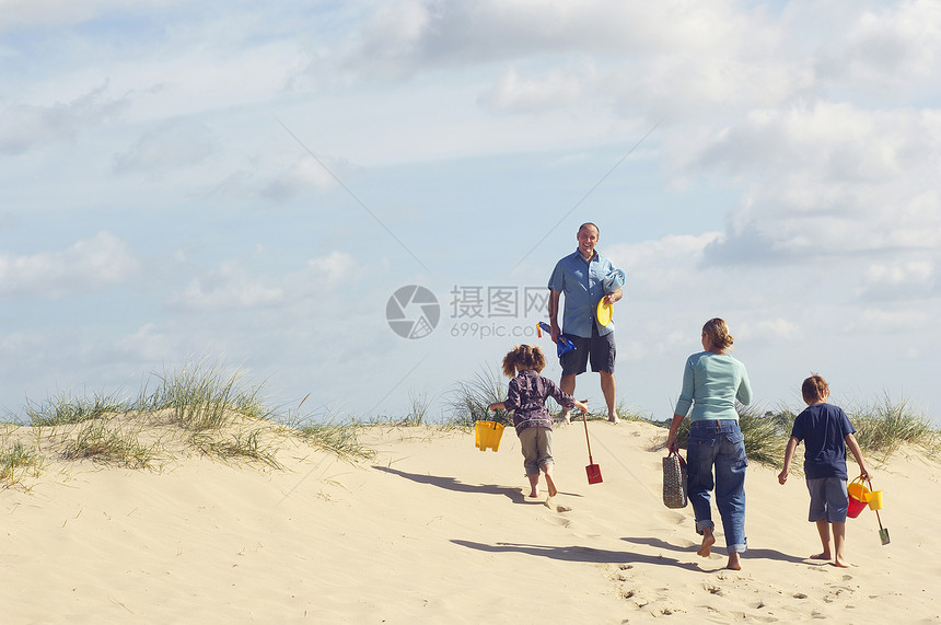 家人在海滩对天上爬沙丘的近视图片