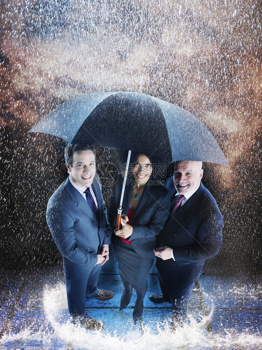 三个商务人士在雨中 一个伞下 一个保护伞下图片