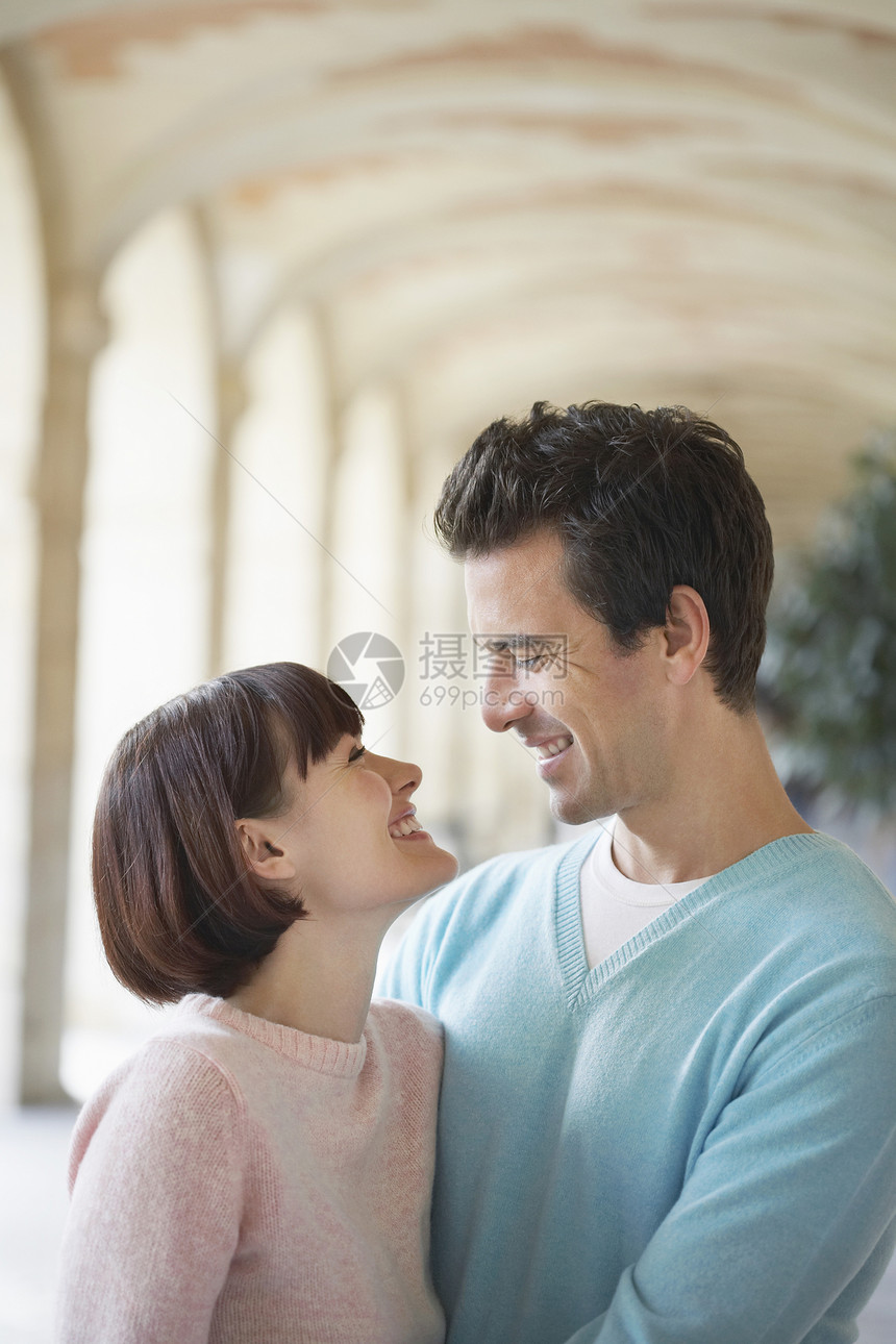 快乐的年轻情侣拥抱在拱门下图片
