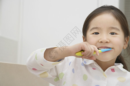 一位年轻女孩刷牙的近镜肖像高清图片