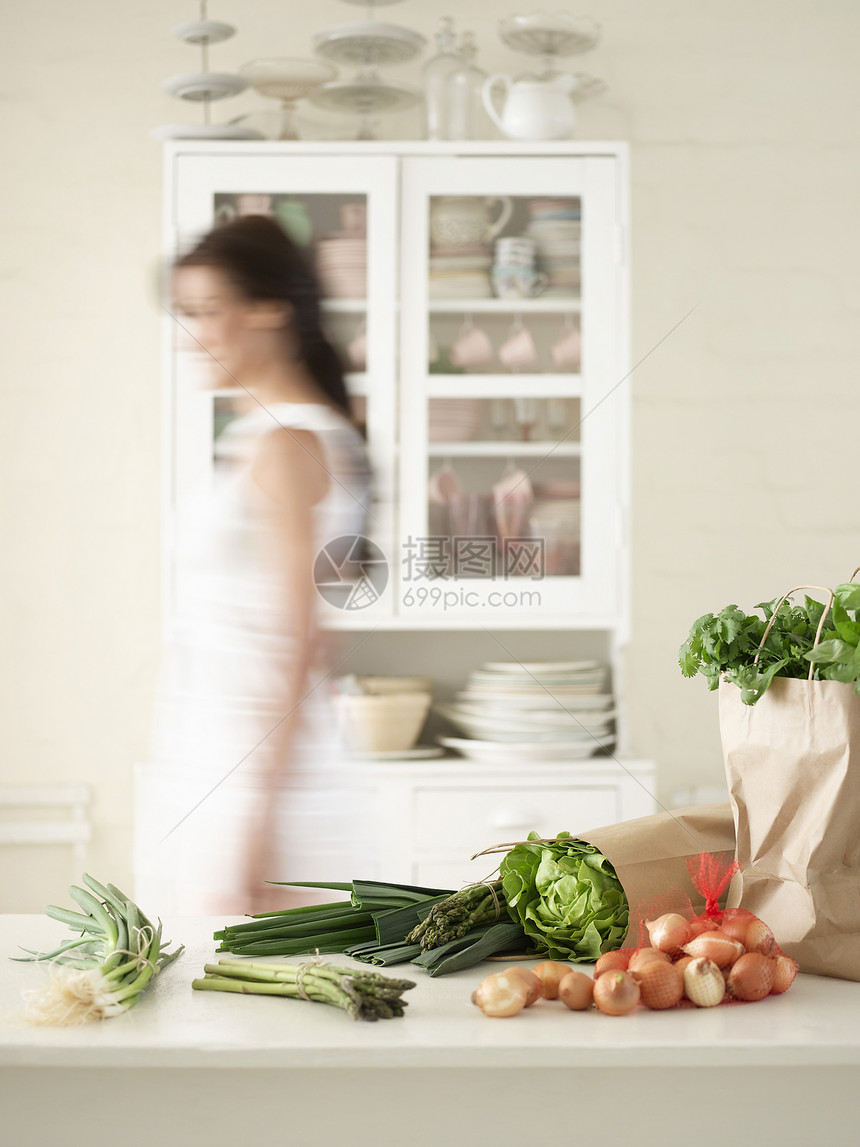 厨房柜台的蔬菜和橱柜中的用具上的餐具图片