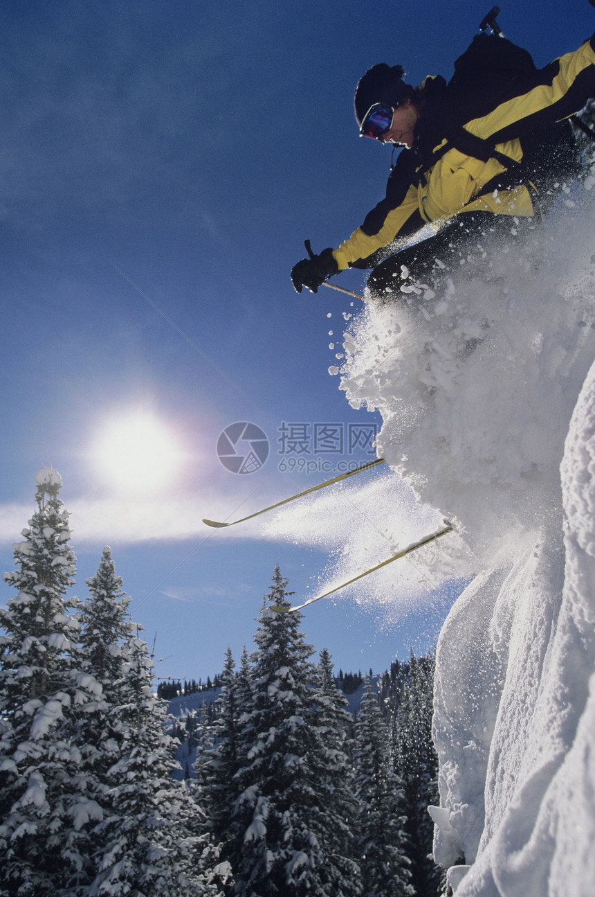 滑雪者从积雪中跳跃到雪中的低角度视图图片