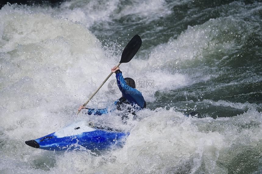 白色水流中男性Kayaker滑行的侧面视图图片