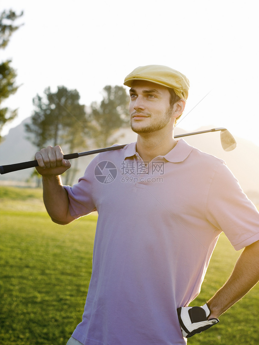自信的年轻男性高尔夫球手在高尔夫球场上俱乐部图片