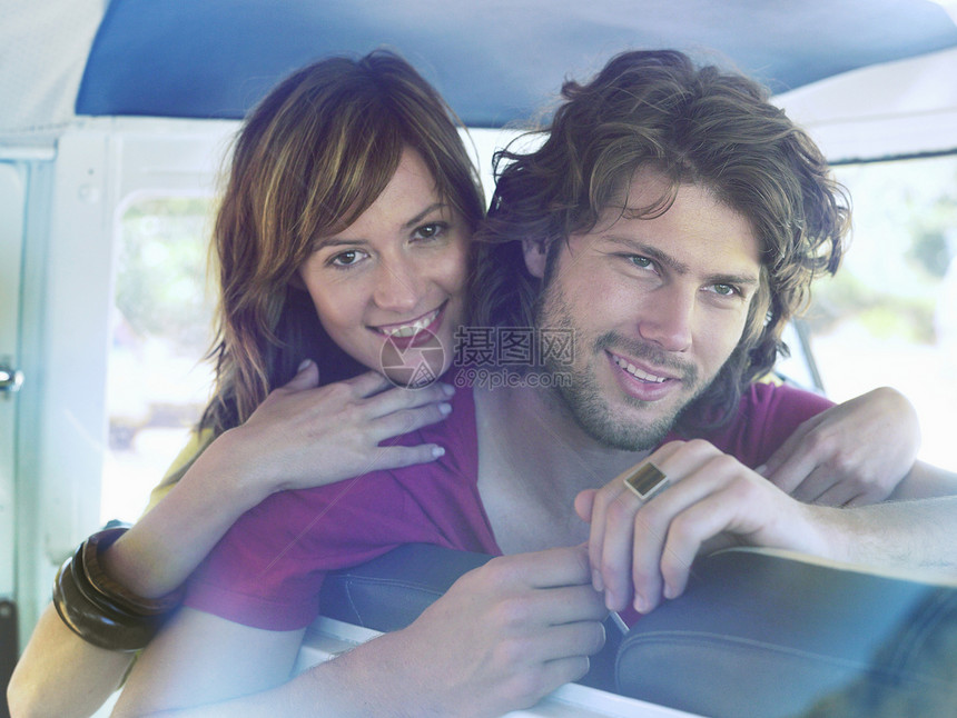 快乐的年轻夫妇靠在面包车座上图片