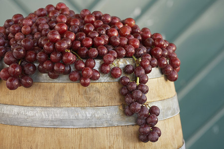 在酒桶上安排红葡萄背景图片