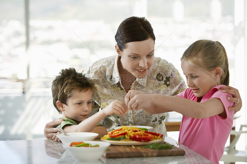 快乐的母亲帮助孩子在厨房做饭 在厨房做饭图片