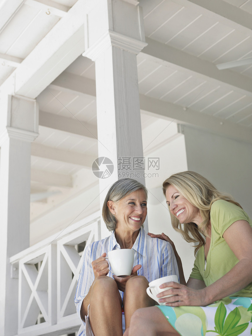 两个快乐的中年妇女 坐在马兰达和咖啡杯上咖啡友谊八卦朋友们低角度婴儿幸福空闲喜悦闲暇图片
