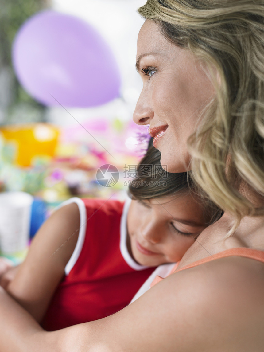 在户外的生日表上 一位年轻母亲和睡着的女儿在室外的生日餐桌前举行紧闭式图片