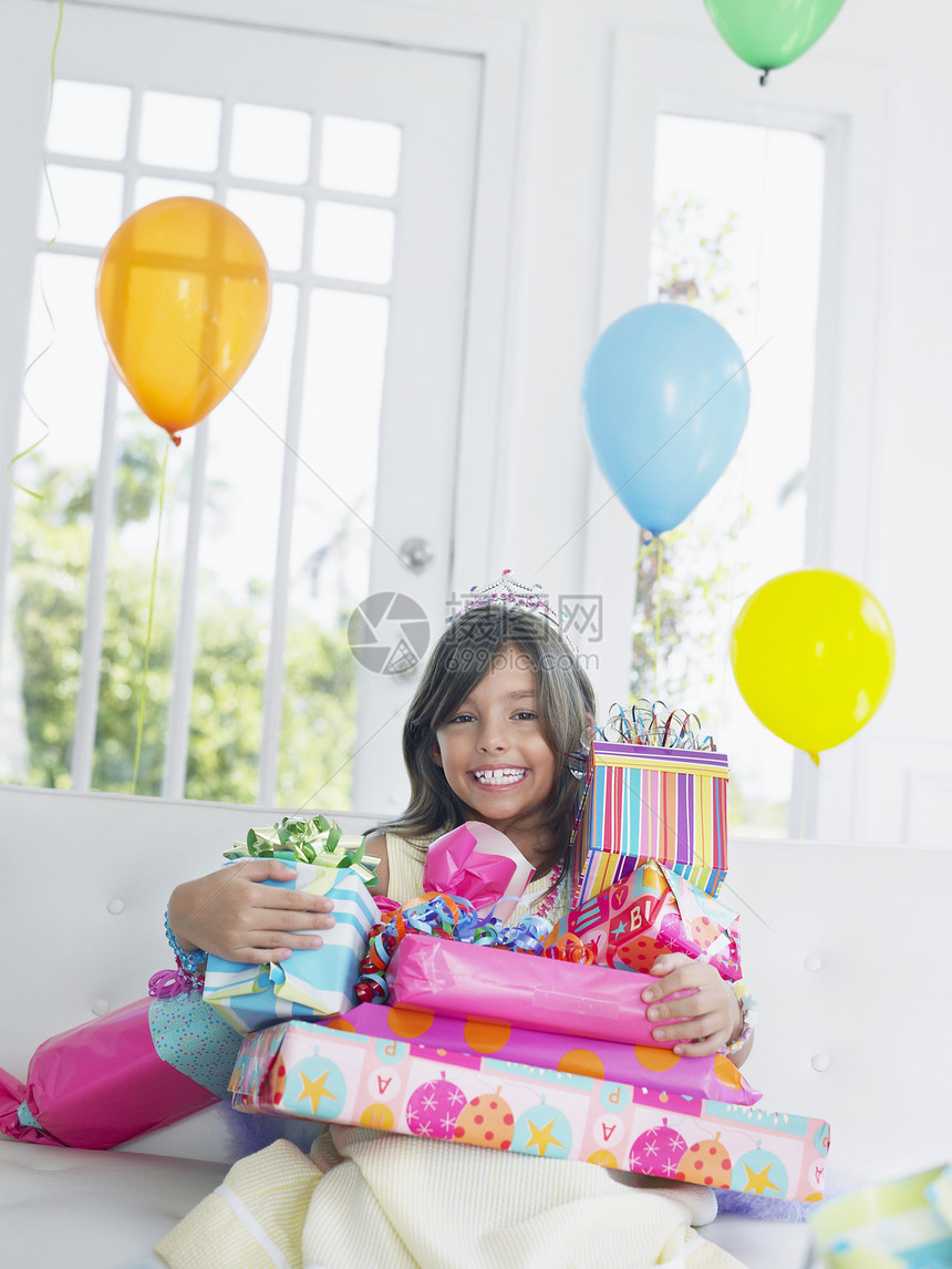 一个年轻女孩的肖像 带着生日礼物微笑童年盒子女性享受沙发幸福闲暇皇冠派对庆典图片