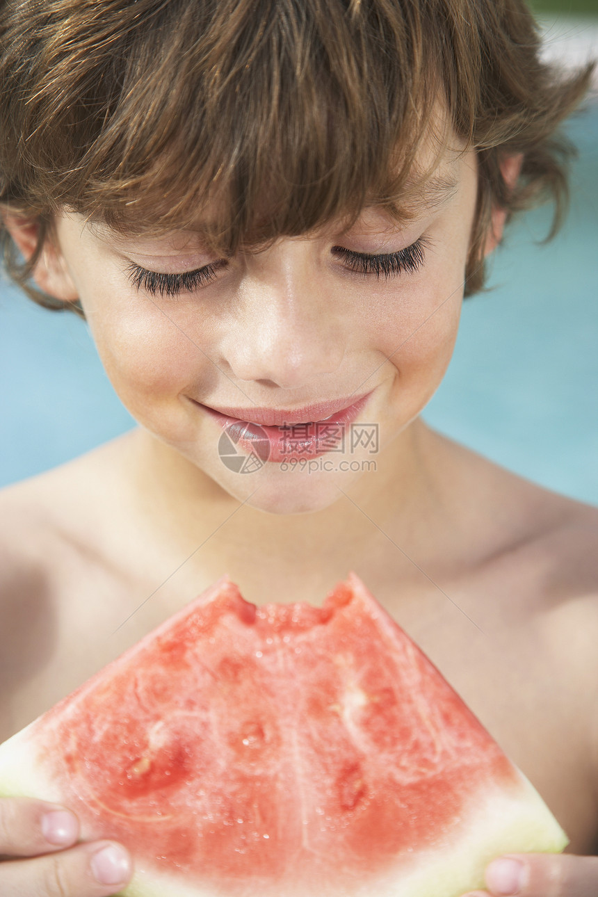 快乐的小男孩吃西瓜的近距离接近图片