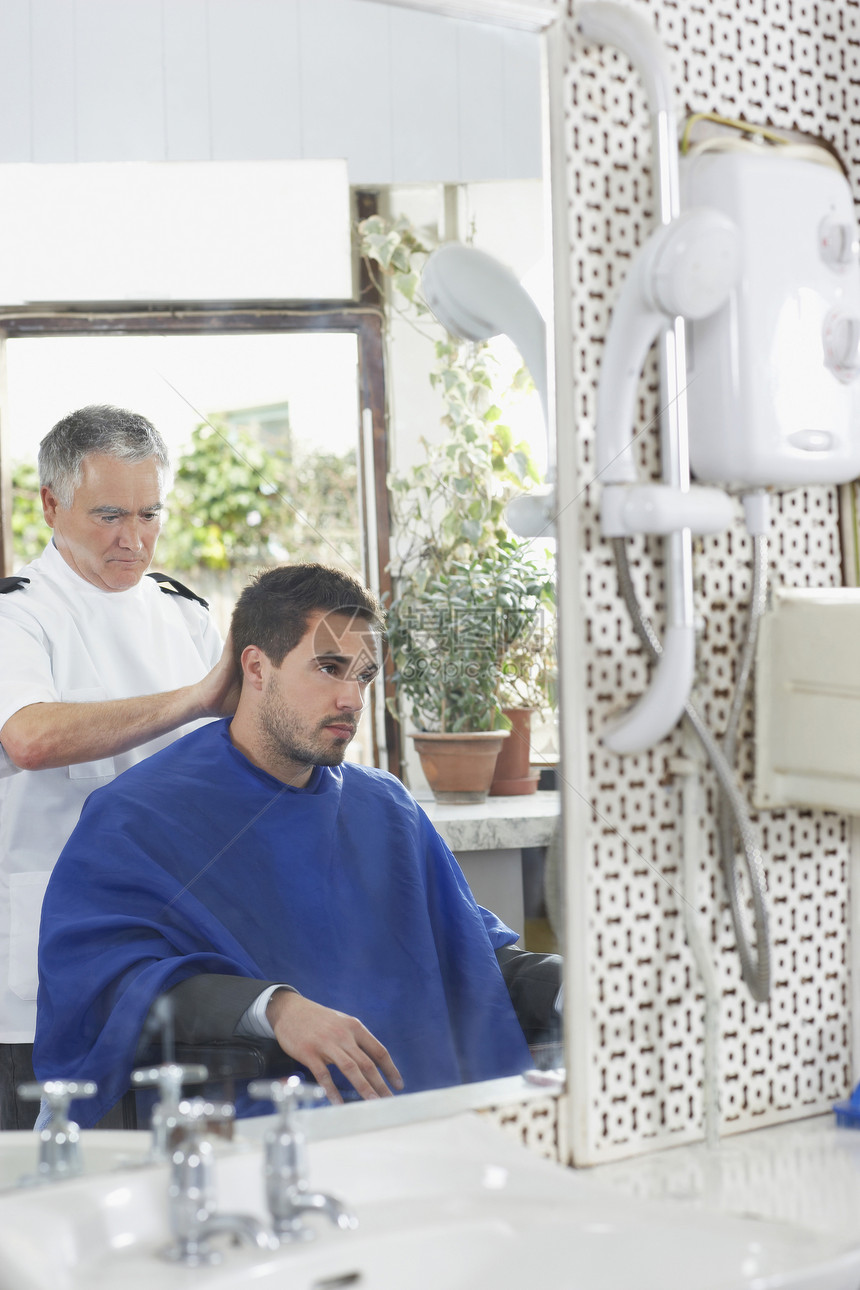 在理发店剪人头发的高级理发师反射工作护理沙龙成人人士镜子理发职业发型图片