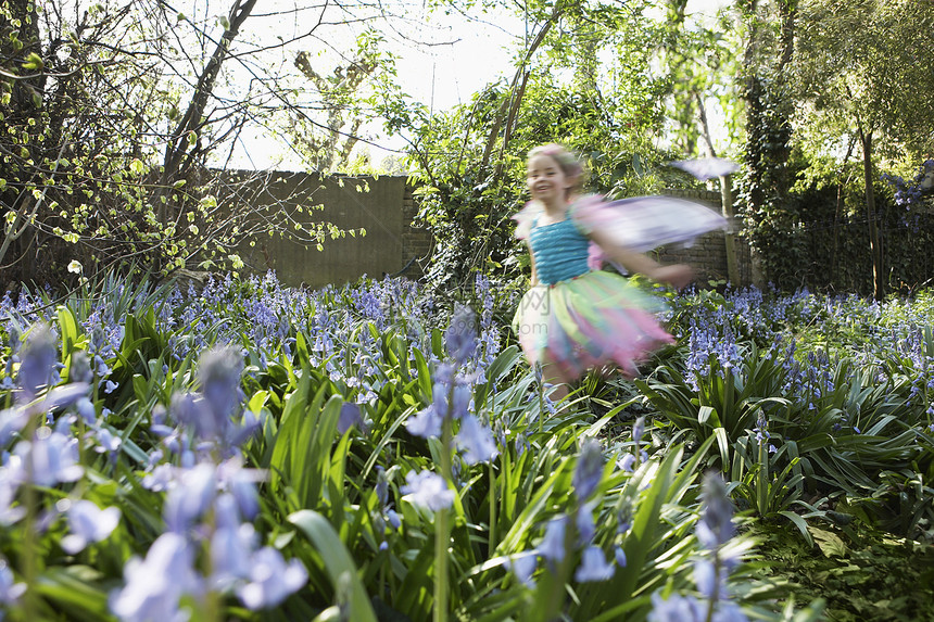 穿着童话装的小女孩 在花花园里跑来跑去图片