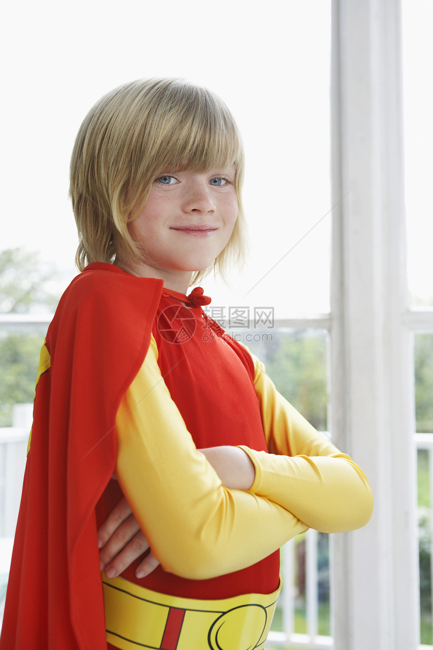 一个微笑男孩的肖像 穿着超级英雄服装 手交叉图片