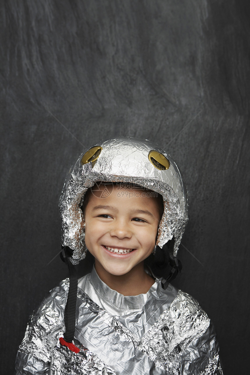 身着铝粉的宇航员服装 在黑人背景下微笑的可爱男孩的肖像图片