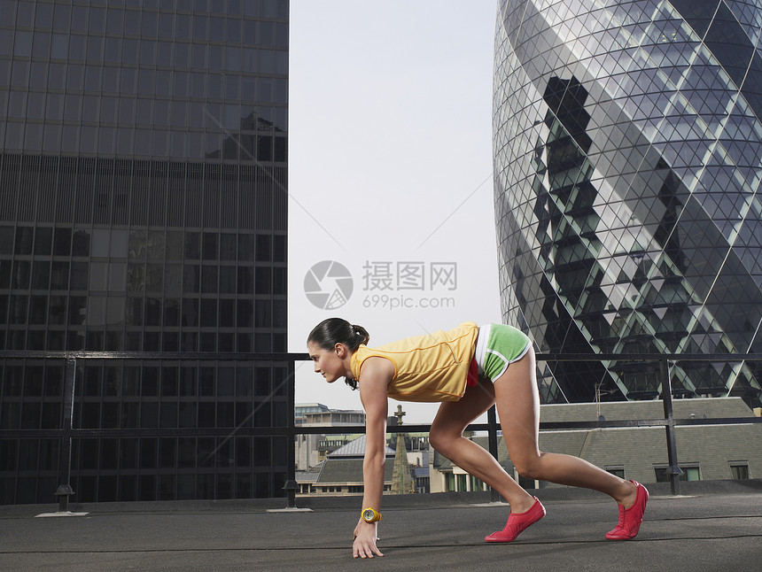 伦敦市中心大楼女赛跑者全长的侧面观 开始位置与伦敦市区大楼对峙图片