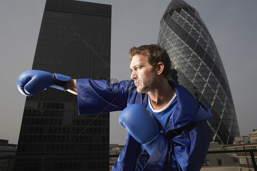 一副男性拳击手对伦敦市中心大楼 进行空中打击的侧面景象图片